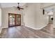 Spacious living room featuring wood-look floors, high ceilings, and wooden French doors to the backyard at 6837 S Roosevelt St, Tempe, AZ 85283