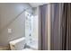 Bathroom with tub-shower combination, gray shower curtain, and gray and white walls at 6847 S 27Th Pl, Phoenix, AZ 85042