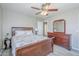 Bedroom features a wood bed frame, matching dresser, ceiling fan, and light wood-look flooring at 6847 S 27Th Pl, Phoenix, AZ 85042