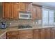 Custom kitchen with wood cabinetry, granite counters, stainless appliances, and a tiled backsplash at 6847 S 27Th Pl, Phoenix, AZ 85042