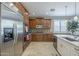 Gourmet kitchen with stainless steel appliances, custom wood cabinets, granite countertops, and travertine floors at 6847 S 27Th Pl, Phoenix, AZ 85042