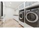 Well-lit laundry room with modern washer and dryer, white cabinetry, counter space, and tiled flooring at 7121 E Rancho Vista Dr # 6001, Scottsdale, AZ 85251