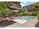 Community pool area featuring a spa, swimming pool, lounge chairs, and lush greenery at 7121 E Rancho Vista Dr # 6001, Scottsdale, AZ 85251