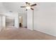 A bedroom with carpeted floors, a ceiling fan, and a partial view of a bathroom at 753 N Port Dr, Gilbert, AZ 85233