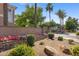 Community entrance sign with colorful flowers, plants, and palm trees, creating a welcoming entry at 753 N Port Dr, Gilbert, AZ 85233