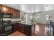 Modern kitchen featuring dark appliances, an island, and ample counter space adjacent to the living area at 753 N Port Dr, Gilbert, AZ 85233