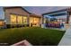 The backyard features a manicured lawn, outdoor seating, and a covered patio with lights at 8127 E June St, Mesa, AZ 85207