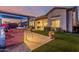 Backyard at dusk with artificial lawn, outdoor kitchen and bar, and covered patio leading inside the home at 8127 E June St, Mesa, AZ 85207