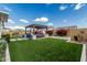 Spacious backyard with artificial turf, a shaded seating area, and manicured landscaping, perfect for outdoor activities and relaxation at 8127 E June St, Mesa, AZ 85207