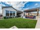 Expansive backyard featuring artificial turf, covered patio with seating, and well-maintained landscaping for outdoor living at 8127 E June St, Mesa, AZ 85207