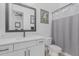 This bathroom features a modern vanity with quartz countertops, matte black fixtures, and gray shower curtain at 8127 E June St, Mesa, AZ 85207