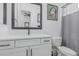 This bathroom features a modern vanity with quartz countertops, matte black fixtures, and gray shower curtain at 8127 E June St, Mesa, AZ 85207
