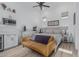 This bedroom features white walls, light wood floors, and a cozy yellow futon at 8127 E June St, Mesa, AZ 85207