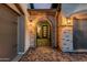 Charming entryway with brickwork, an arched doorway, and decorative lighting, leads to a stylish front door at 8127 E June St, Mesa, AZ 85207