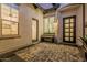 The outdoor seating area has tiled flooring, a decorative bench, multiple windows and paneled front door at 8127 E June St, Mesa, AZ 85207