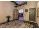 Arched entrance with a wrought iron gate and tiled flooring lead to the cozy and inviting front courtyard at 8127 E June St, Mesa, AZ 85207
