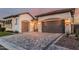 Inviting exterior showcasing a paved driveway, multiple car garage and wrought iron gate to the front door at 8127 E June St, Mesa, AZ 85207