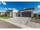 A home with a two car garage, well manicured xeriscaping, pristine artificial turf and a paver driveway at 8127 E June St, Mesa, AZ 85207