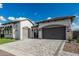 A home with a two car garage, well manicured xeriscaping, pristine artificial turf and a paver driveway at 8127 E June St, Mesa, AZ 85207