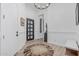 Elegant foyer boasts light wood floors, modern chandelier, decorative rug, and a black grid-paneled door at 8127 E June St, Mesa, AZ 85207