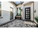 Inviting front entrance showcasing a unique bench, black grid-paneled door, and patterned brickwork for added curb appeal at 8127 E June St, Mesa, AZ 85207