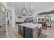 Open-concept kitchen with a central island, pendant lighting, and seamless flow into the dining and living spaces at 8127 E June St, Mesa, AZ 85207