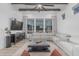 Bright living room featuring a ceiling fan, white sectional sofa, and large windows offering great natural light at 8127 E June St, Mesa, AZ 85207