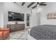 Main bedroom featuring a TV, dresser, ceiling beams, and a comfortable seating area at 8127 E June St, Mesa, AZ 85207