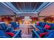 Outdoor covered patio with fireplace, pergola, blue sofas, and manicured plants at twilight at 8127 E June St, Mesa, AZ 85207