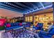 Covered patio at dusk with modern furniture, a ceiling fan, and views of a manicured backyard at 8127 E June St, Mesa, AZ 85207