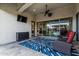 Inviting covered patio with ceiling fan, TV, stylish rug, and comfortable seating for outdoor relaxation and entertainment at 8127 E June St, Mesa, AZ 85207