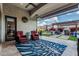 Covered patio featuring two red chairs and a view of the landscaped backyard and BBQ area at 8127 E June St, Mesa, AZ 85207