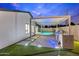 This backyard features a sparkling pool, outdoor kitchen, and turf with stone walkways at 8430 E Fairmount Ave, Scottsdale, AZ 85251
