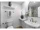 Well-lit bathroom with decorative vases on floating shelves, a tile shower, and a traditional toilet and sink at 8430 E Fairmount Ave, Scottsdale, AZ 85251