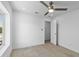 Bright, minimalist bedroom with ceiling fan and open doorway at 8430 E Fairmount Ave, Scottsdale, AZ 85251
