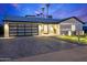 Charming home with a modern garage, and a well-lit walkway. Palm trees add to the curb appeal at 8430 E Fairmount Ave, Scottsdale, AZ 85251