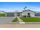 Charming single-story home featuring a modern design with a lush green lawn and a sleek garage door at 8430 E Fairmount Ave, Scottsdale, AZ 85251