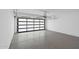 Garage featuring a modern glass panel garage door and sleek polished concrete floor at 8430 E Fairmount Ave, Scottsdale, AZ 85251
