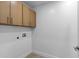 Bright laundry room featuring storage cabinets above the washer/dryer hookups at 8430 E Fairmount Ave, Scottsdale, AZ 85251