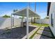 Outdoor grill area with stainless grill and sink under a pergola, artificial turf, and backyard golf at 8430 E Fairmount Ave, Scottsdale, AZ 85251