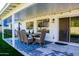 Covered outdoor dining area, complemented by a blue rug, and views of the well-maintained lawn at 864 W Monte Ave, Mesa, AZ 85210
