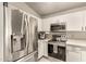 Bright kitchen boasts stainless steel appliances, sleek white cabinets, and undermount microwave at 875 S Nebraska St # 69, Chandler, AZ 85225