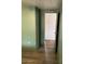 Hallway with light green walls, laminate flooring and an open doorway at 9427 E University Dr # 48, Mesa, AZ 85207