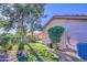 Well maintained backyard featuring green grass, lush landscaping, and a charming patio area at 9967 W Devonshire Ave, Phoenix, AZ 85037