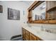 Bathroom featuring a wooden vanity mirror with a double sink at 9967 W Devonshire Ave, Phoenix, AZ 85037