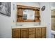 Bathroom with a wooden vanity mirror and a double sink at 9967 W Devonshire Ave, Phoenix, AZ 85037
