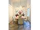 A formal dining room features a large table with seating for eight, contemporary art, and ample natural light at 9967 W Devonshire Ave, Phoenix, AZ 85037