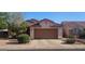 Traditional single Gathering home with a tile roof, brown garage door, desert landscaping, and a concrete driveway at 9967 W Devonshire Ave, Phoenix, AZ 85037