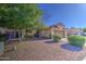 Well-maintained front exterior with a two-car garage, desert landscaping, and mature trees in a residential area at 9967 W Devonshire Ave, Phoenix, AZ 85037
