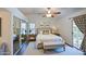 Bright bedroom with a ceiling fan, a light colored bed, mirrored closet doors, and access to the backyard at 9967 W Devonshire Ave, Phoenix, AZ 85037